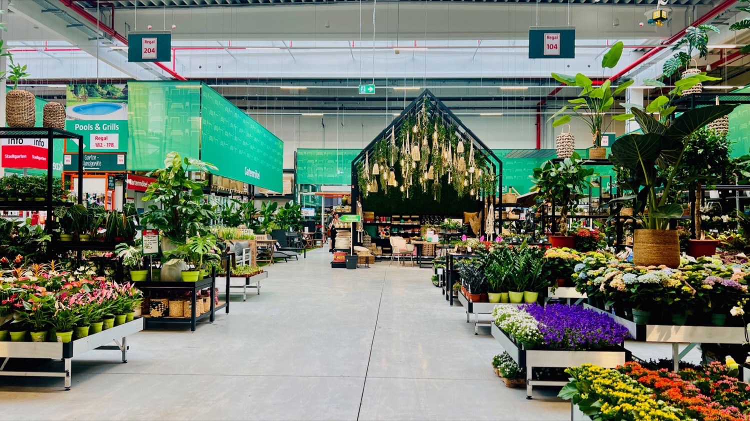 Bauhaus Stadtgarten: main aisle of the plant department with green department signage and a planted gable feature
