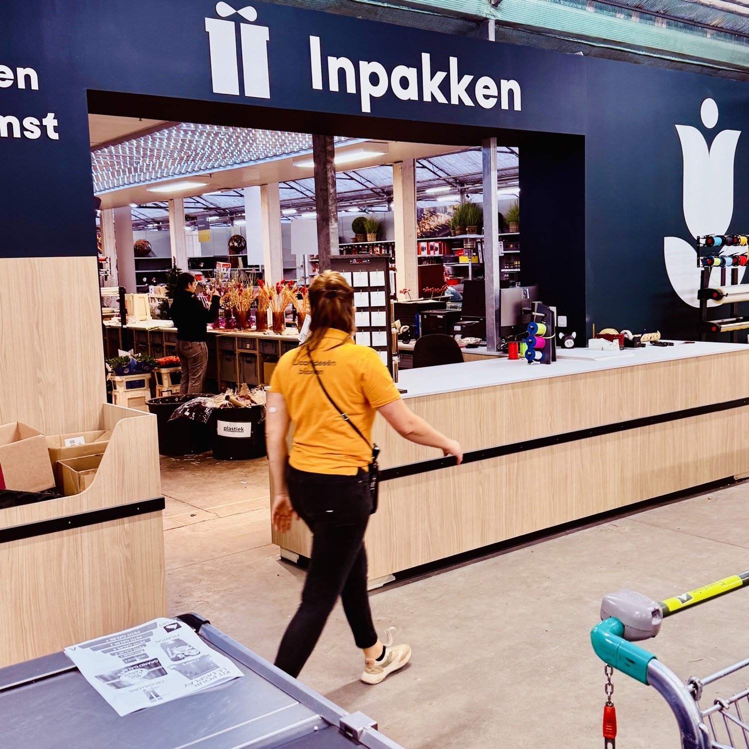 Eurotuin Merelbeke: the gift wrapping service counter in oak and dark navy, with staff at work